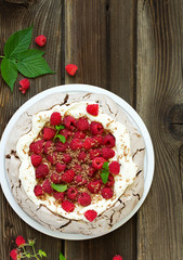 Chocolate dessert (pie) of pavlov with cream and raspberries.