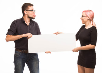 Young playful couple portrait of a confident businessman showing presentation, pointing paper placard background. Ideal for banners, registration forms, presentation, landings, presenting concept.