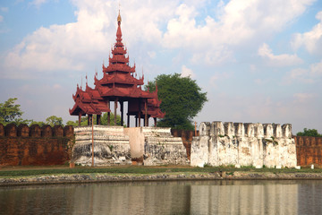The old gate with a bastion in the old city on a cloudy evening. Mandalay, Burma