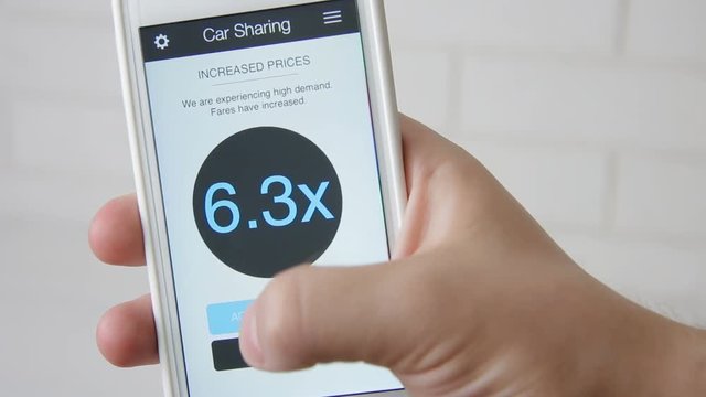 Man requests car and accepts high rates using car sharing application on smartphone