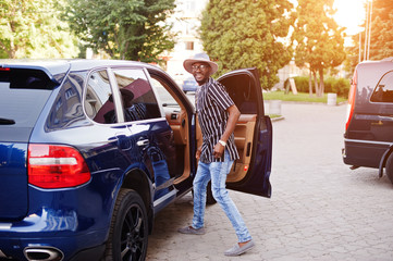 Black men wearing cool traditional clothes in the minivan.