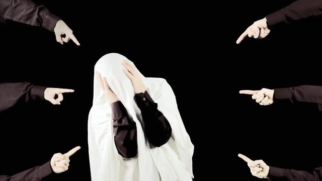 A man hiding under a blanket, desperately trying to avoid many hands pointing at him. Symbolic shot: guilt trap, shame, sin, stigma. Redux.
