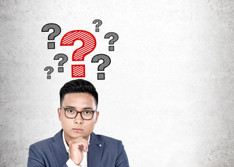 Pensive Asian man and question marks