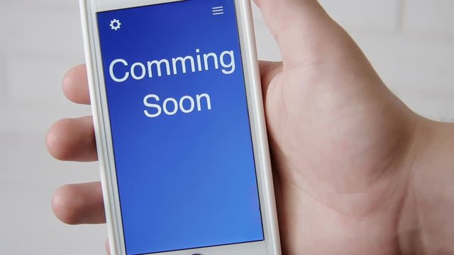 Coming Soon Concept Application On The Smartphone. Man Uses Mobile App.