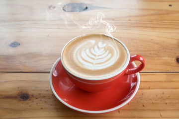 red coffee cup on wooden in coffee shop background
