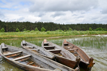 Fototapeta na wymiar Old rustic wooden fishing boats on the lake at stormy weather, close up
