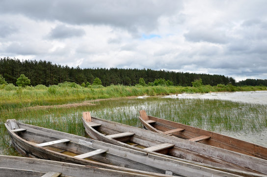 Old rustic wooden fishing boats on the lake at stormy weather, close up