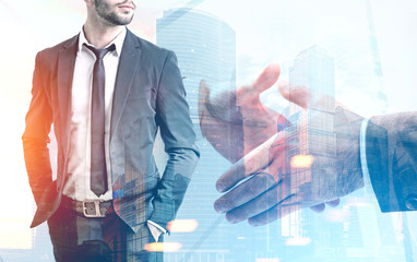 Fototapeta premium Close up of a handshake, cityscape, man