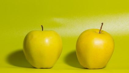 closeup, yellow Apple on a green background.
