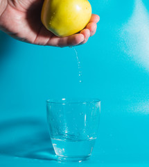 in a glass of water falling drops of water with Apple in hand.