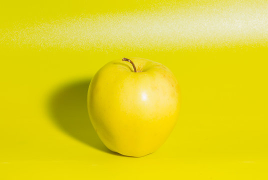 yellow Apple on green background, closeup.