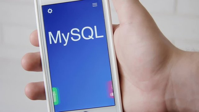 MySQL concept application on the smartphone. Man uses mobile app.