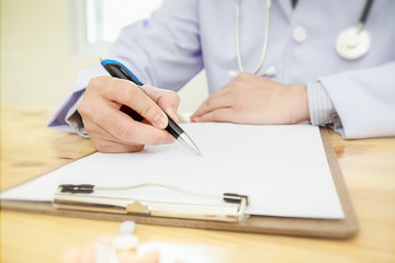 Doctor working in hospital writing a prescription, Healthcare and medical concept,Stethoscope with clipboard,test results in background,vintage color,selective focus