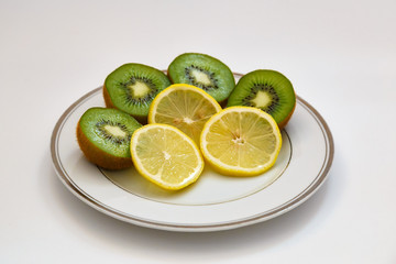 Kiwi and lemon on a white plate