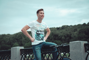 A man is riding a bicycle in a park on the waterfront
