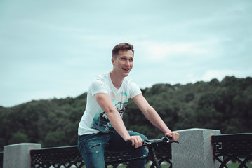 A man is riding a bicycle in a park on the waterfront
