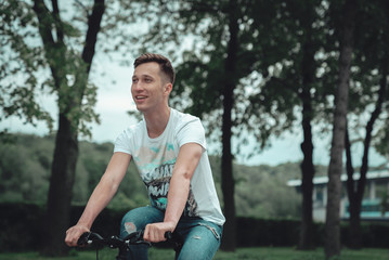 A man is riding a bicycle in a park on the waterfront