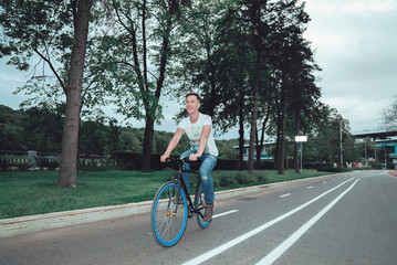 A man is riding a bicycle in a park on the waterfront
