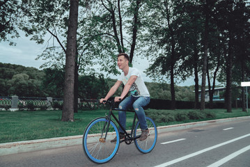 A man is riding a bicycle in a park on the waterfront