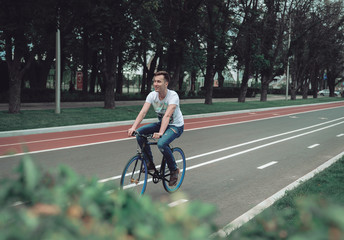 A man is riding a bicycle in a park on the waterfront