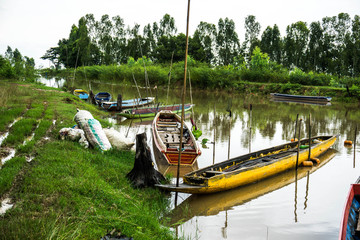 Obraz premium Long tail boat in Thailand's muddy clear waters with morning sunshine.