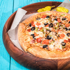 Vegetarian pizza with vegetables on blue table.