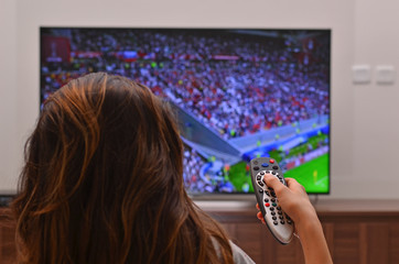 women watching a soccer game on tv and use remote controller