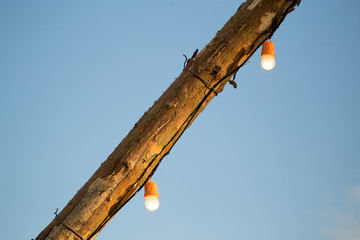 The bulb burns on a wooden pole
