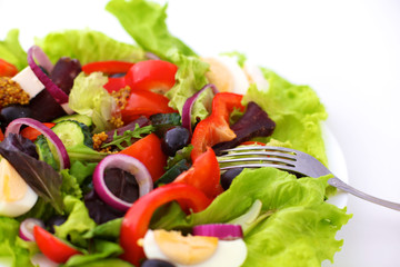 salad from fresh vegetables in a plate on a table, selective focus