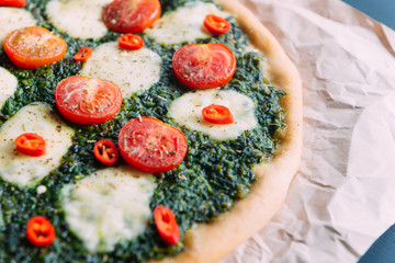 Appetizing pizza with pesto mozzarella and cherry and chili peppers