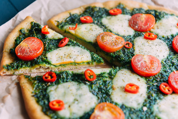 Appetizing pizza with pesto mozzarella and cherry and chili peppers