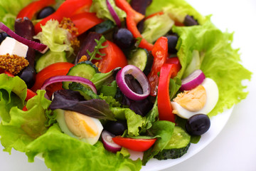 salad from fresh vegetables in a plate on a table, selective focus