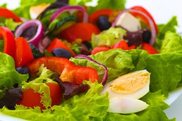 salad from fresh vegetables in a plate on a table, selective focus