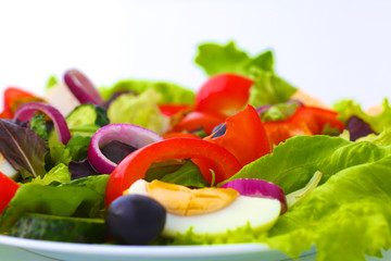 salad from fresh vegetables in a plate on a table, selective focus
