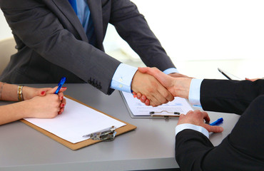 Business meeting at the table shaking hands conclusion of the contract