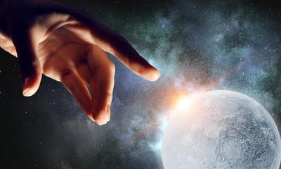 Obraz na płótnie Canvas Hand touching the moon