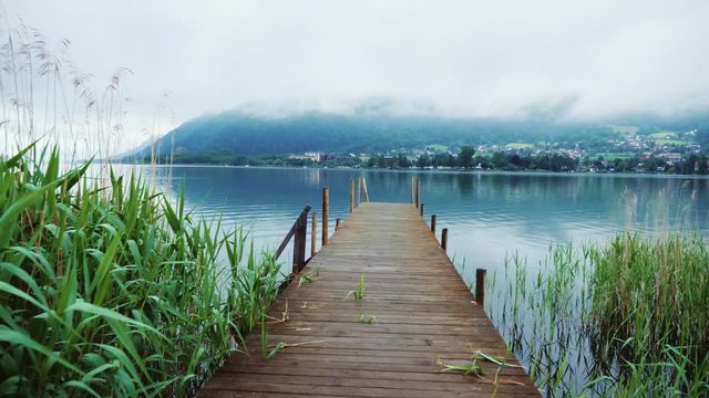 Old wooden pier on a picturesque mountain lake in the Alps in Austria. Steaducam shot