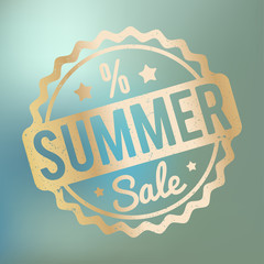 Summer Sale rubber stamp gold on a blue bokeh background.