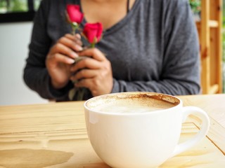 Woman drinking coffee cup and red rose in valentines day