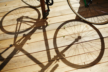 Shadow of bicycle on wooden terrace