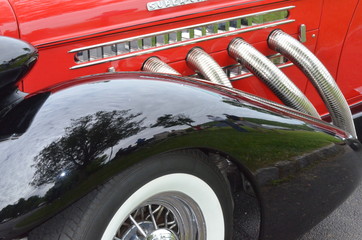 classic red roadster with chrome exhaust pipes