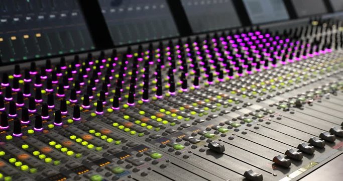  Professional audio mixer. A small depth of field, flickering light bulbs.Hands of Audio engineer working. Sound engineer, producer control engineer, audio mixing console