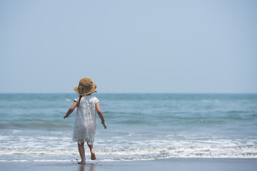 Happy little girl playing on the beach