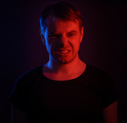 Portrait of a man with colored light and dark background.