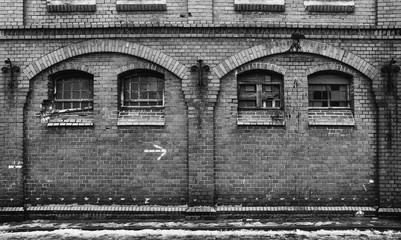 Fototapeta na wymiar Big old brick wall with windows BW