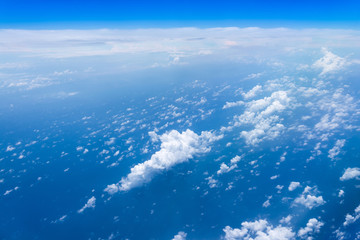 Flying into blue sky and sea of fantasy row clouds and Wing of airplane with skyline  top view as look from window airplane, during flight space for  text message, frame or traveling idea concept