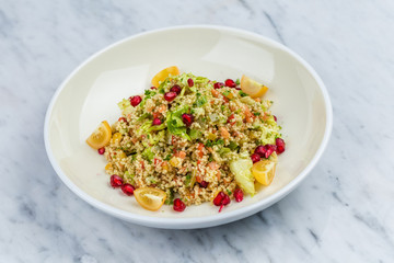 Quinoa salad with pomegranate in white plate