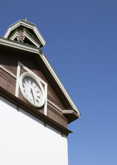 Clock on the old house with Carved wooden decor, sunny day, minimalist landscape, blue sky, Ukraine, Kyiv city
