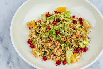 Quinoa salad with pomegranate in white plate