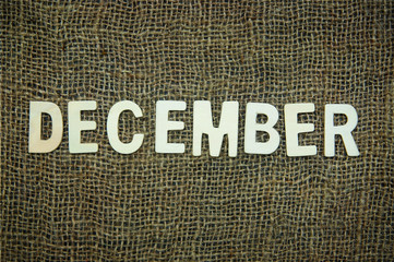 December Cardboard Text Over Sackcloth